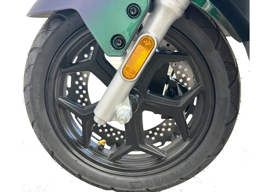 Close-up of electric scooter front wheel with alloy rim, disc brake system, and front suspension fork