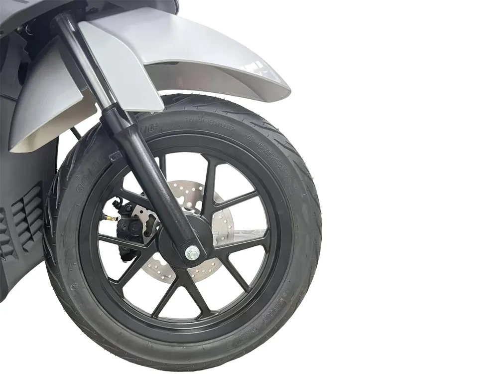 Close-up of electric scooter front wheel showing alloy rim, tire, front disc brake, and suspension fork