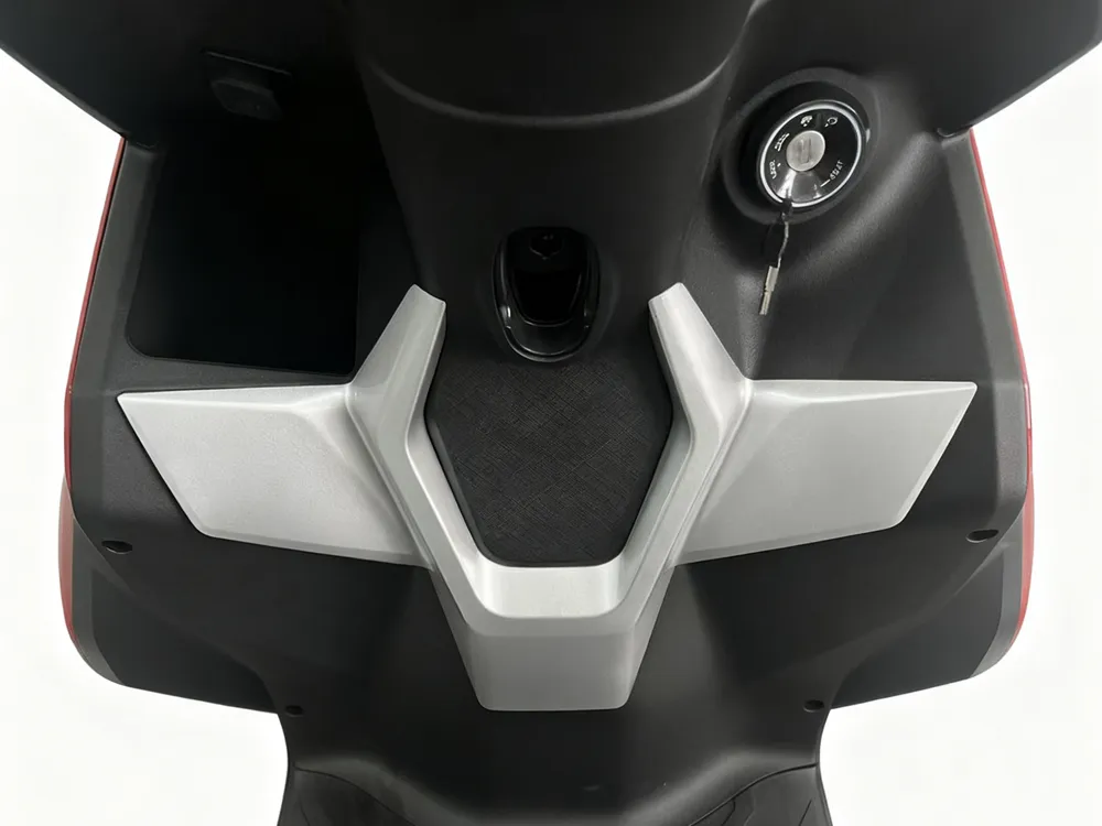 Close-up of electric scooter ignition button and handlebar control panel showing ergonomic design and high-quality material finish